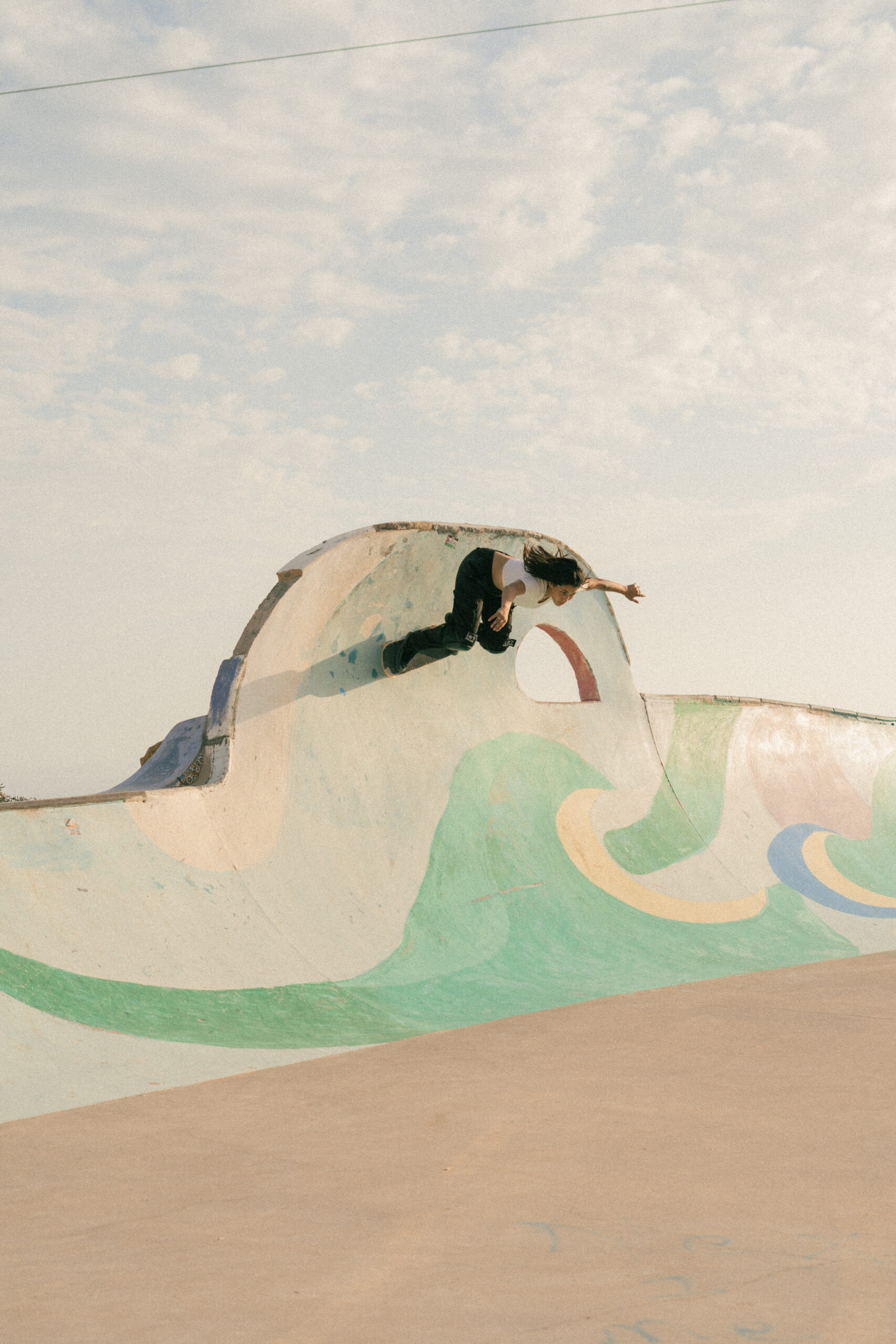 Skatergirl skating the bowl in Taghazout Skatepark
