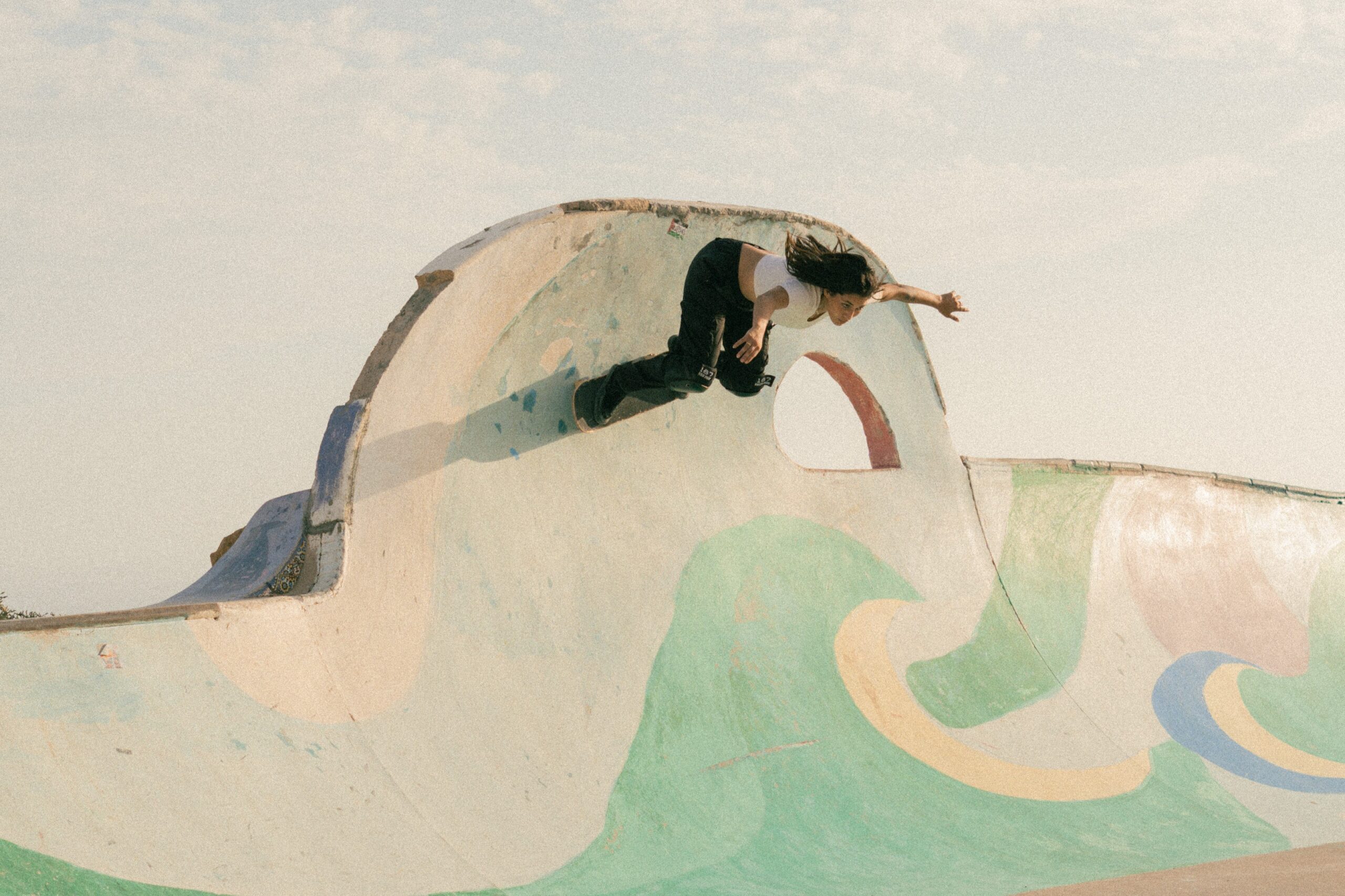 Skatergirl skating the bowl in Taghazout Skatepark