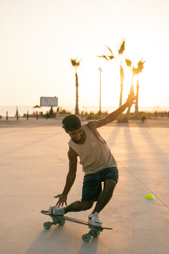 Skaterboy doing a turn on the surf skate in front of anza beach, agadir