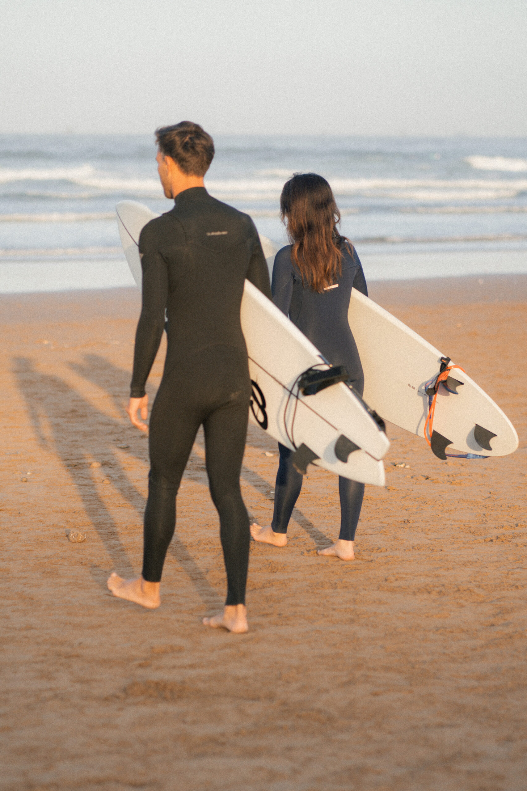 Two Surfers entering the waves at anza beach, agadir